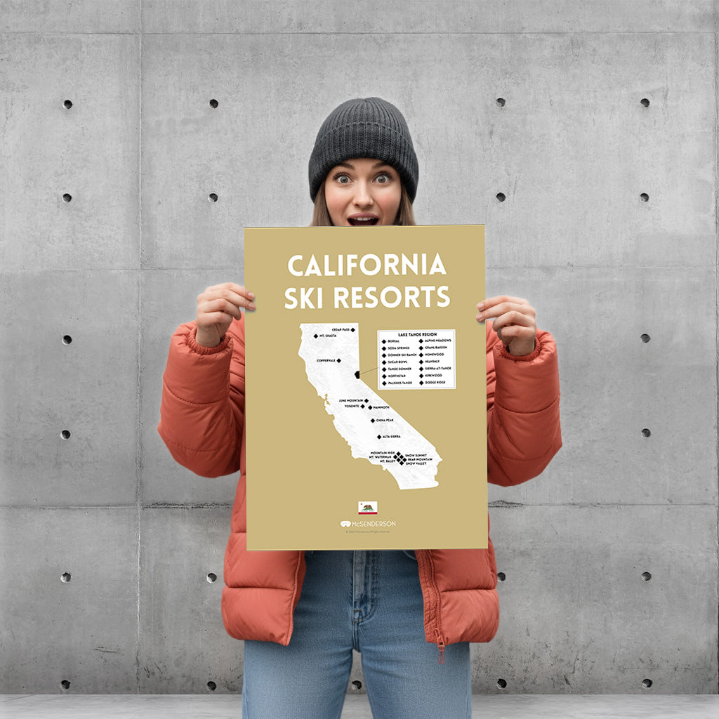 Person holding a 'California Ski Resorts' map against a concrete wall