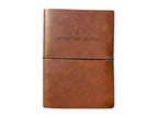 McSenderson brown leather-bound adventure journal with embossed mountain detail and elastic closure.