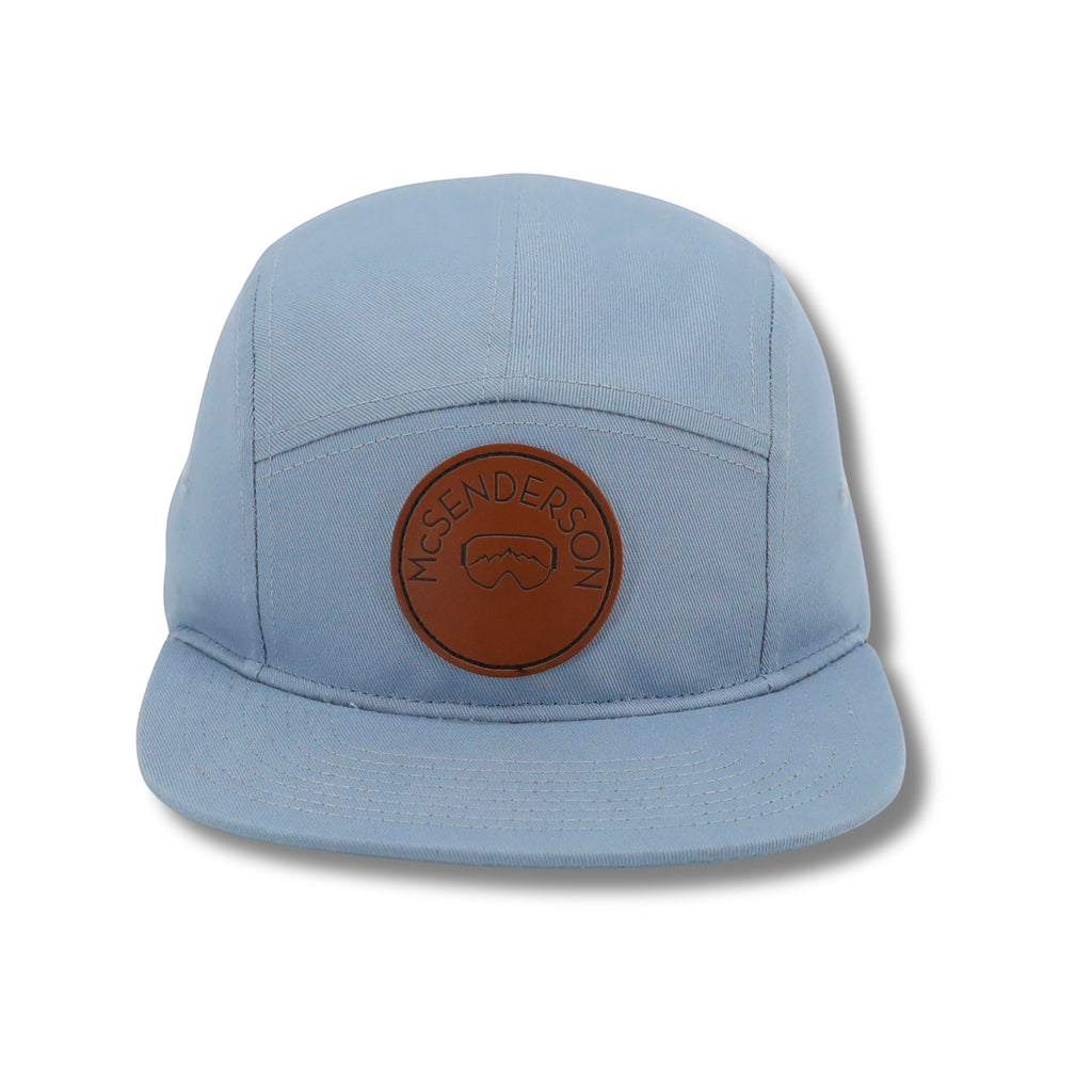 McSenderson light blue 5-panel camper hat with a brown leather patch featuring ski goggles.